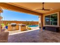 Relaxing covered patio area with built-in BBQ and access to the pool and low-maintenance desert landscaping at 27537 W Yukon Dr, Buckeye, AZ 85396