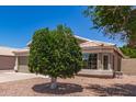 Tan single-story home with a tile roof and low maintenance desert rock front yard at 280 W Sheffield Ave, Gilbert, AZ 85233