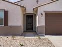 Welcoming front entryway with a dark door, stone landscaping and a covered porch at 37385 W San Sisto Ave, Maricopa, AZ 85138