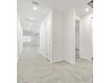 Bright hallway featuring neutral colored tile floor, white walls, doors, and trim throughout at 37399 W San Sisto Ave, Maricopa, AZ 85138