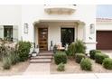 Inviting covered front porch with brick steps, chairs and lush landscaping at 3927 E Sheila Ln, Phoenix, AZ 85018