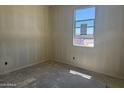 An unfinished bedroom with a window and a concrete floor awaits personalization at 4521 S 95Th Dr, Tolleson, AZ 85353