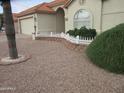 Manicured front yard featuring desert landscaping, a small white fence, and mature trees at 6230 S Championship Dr, Chandler, AZ 85249