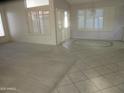 Bright living room featuring a combination of carpet and tile flooring, with plantation shutters at 6230 S Championship Dr, Chandler, AZ 85249