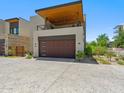 Modern home exterior showcasing a spacious balcony, wood accents, and a two-car garage at 6311 E Phoenician Blvd # 19, Scottsdale, AZ 85251