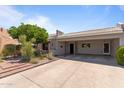 Front exterior of home featuring desert landscaping and an extended driveway with a covered carport at 7611 E Pasadena Ave, Scottsdale, AZ 85250