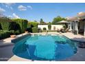 Inviting backyard pool with lush landscaping and a patio area perfect for entertaining at 7648 W Mauna Loa Ln, Peoria, AZ 85381