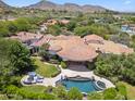 Stunning aerial view of estate featuring a pool, spa, lush landscaping, and a gorgeous home with a Spanish tile roof at 8329 N Ridgeview Dr, Paradise Valley, AZ 85253