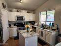 Bright kitchen featuring white cabinets, stainless steel appliances and granite countertops with an island centerpiece at 9252 W Carol Ave, Peoria, AZ 85345