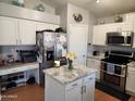 Modern kitchen featuring white cabinets, stainless steel appliances, island and an adjacent desk area at 9252 W Carol Ave, Peoria, AZ 85345