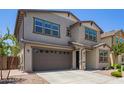 Two-story home with a brown two-car garage, desert landscaping, and neutral paint scheme at 1081 E Armstrong Way, Chandler, AZ 85286
