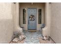 Welcoming front entrance with a decorative door, stylish wreath, and charming accents, enhancing curb appeal at 10909 W Chase Ln, Avondale, AZ 85323