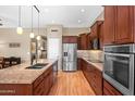 Modern kitchen with stainless steel appliances, granite countertops, and wood cabinets at 11553 W Cottontail Ct, Surprise, AZ 85378