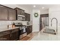 Modern kitchen with stainless steel appliances, granite countertops, and dark wood cabinetry at 13380 N 148Th Ave, Surprise, AZ 85379