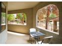 Cozy balcony with table and chairs, overlooking the community pool and lush landscaping for outdoor enjoyment at 15252 N 100Th St # 1172, Scottsdale, AZ 85260