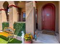 Inviting front porch area with a charming bench and beautifully decorated entrance at 15416 W Valentine St, Surprise, AZ 85379