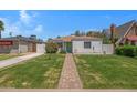 Charming single-story home features a brick pathway, lush lawn, and vibrant landscaping at 1618 W Vernon Ave, Phoenix, AZ 85007