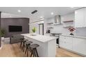 Stylish kitchen boasts white cabinets, a large island with seating, and modern stainless steel appliances at 1624 E Campbell Ave # 51, Phoenix, AZ 85016