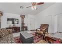 Cozy living room with tile flooring, a ceiling fan, and comfortable seating arrangement under bright lighting at 16654 N 19Th Pl, Phoenix, AZ 85022