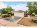 Well-maintained home with a two-car garage, desert landscaping, and a neutral color palette at 17128 N Princess Pl, Surprise, AZ 85374