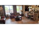 Welcoming living room featuring a cozy leather sofa, elegant decor, and a seamless flow to the dining area at 18177 W Tasha Dr, Surprise, AZ 85388