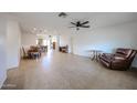 Spacious living room features tile flooring, a ceiling fan, and an open concept to the dining and kitchen areas at 2222 E Gretta Pl, Phoenix, AZ 85022