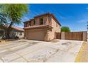 Charming two-story home featuring a red tile roof, tan stucco, and a spacious two-car garage at 304 E Beth Dr, Phoenix, AZ 85042