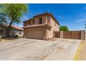 Side view of a two-story home featuring a spacious driveway and a private gated entrance at 304 E Beth Dr, Phoenix, AZ 85042