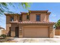 Charming two-story home featuring a red tile roof, tan stucco, and a spacious two-car garage at 304 E Beth Dr, Phoenix, AZ 85042