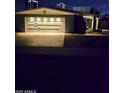 Inviting single-story home features a garage with stylish lighting, enhancing its curb appeal during nighttime at 3137 N 4Th Ave, Phoenix, AZ 85013
