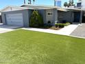 This single-story home boasts an artificial lawn, gray exterior, and a convenient attached garage in a sunny neighborhood at 3137 N 4Th Ave, Phoenix, AZ 85013