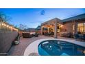 Inviting backyard featuring a covered patio, outdoor kitchen, cozy seating around a fire pit and a sparkling pool at 3521 N Barron --, Mesa, AZ 85207
