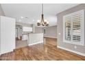 Bright dining room with wood floors, modern chandelier, and a view into the kitchen at 3565 E Meadowview Dr, Gilbert, AZ 85298