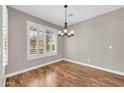 Bright, empty room with wood floors, plantation shutters, and neutral paint at 3565 E Meadowview Dr, Gilbert, AZ 85298