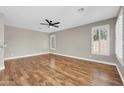 Spacious living room with wood floors, ceiling fan, and plantation shutters at 3565 E Meadowview Dr, Gilbert, AZ 85298