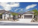 Charming single-story home with desert landscaping, a stone accent wall, and solar panels at 4512 W Rushmore Dr, Anthem, AZ 85087