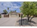 Single story home featuring desert landscaping, mature trees, and wide driveway at 5330 E Tierra Buena Ln, Scottsdale, AZ 85254