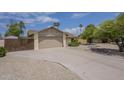 Wide driveway leading to a two car garage, desert landscaping and gated side yard at 5330 E Tierra Buena Ln, Scottsdale, AZ 85254