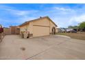 Single-story home featuring a tan exterior, a two-car garage, and a spacious driveway at 7114 W Oregon Ave, Glendale, AZ 85303