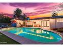 Inviting backyard with a sparkling pool, patio area, outdoor kitchen, and Arizona flag feature wall at 7308 E Diamond St, Scottsdale, AZ 85257