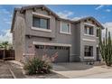 Two-story home featuring a two-car garage, landscaped front yard with desert rock and drought resistant plants at 7308 S 29Th Ln, Phoenix, AZ 85041