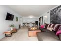 Open-concept living room with sectional, ottoman, television, and dining area with views to hallway and bathroom at 8500 E Indian School Rd # 233, Scottsdale, AZ 85251
