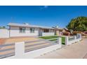 Single-story home with a manicured front yard, painted fence, and a well-lit entryway at 8802 W Monterey Way, Phoenix, AZ 85037