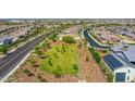 Expansive aerial view of a community featuring open green spaces, nearby roads and multiple residential homes at 9157 W Country Club Trl, Peoria, AZ 85383