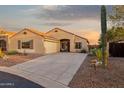 Attractive single-story home with a concrete driveway, desert landscaping, and an attached two-car garage at 10109 E Trailhead Ct, Gold Canyon, AZ 85118