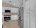 Modern kitchen with stainless steel appliances, white cabinets, and a gas range stove at 10305 E Plata Ave, Mesa, AZ 85212