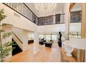 Spacious foyer with high ceilings, a grand chandelier, staircase, and views into the dining and living areas at 10344 E Trillium Ave, Mesa, AZ 85212