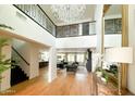 Elegant foyer featuring high ceilings, a grand chandelier, and light wood flooring at 10344 E Trillium Ave, Mesa, AZ 85212