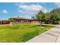 Attractive one-story brick house with lush green lawn, mature trees, and an attached garage at 1062 E Watson Dr, Tempe, AZ 85283