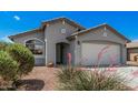 Charming home featuring manicured front yard, desert landscaping, and a two-car garage at 10755 W Mountain View Dr, Avondale, AZ 85323